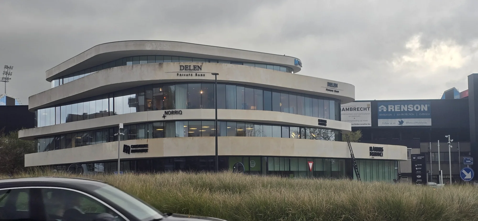 Budynek biurowy z zabrudzoną elewacją betonową przed myciem – widok boczny